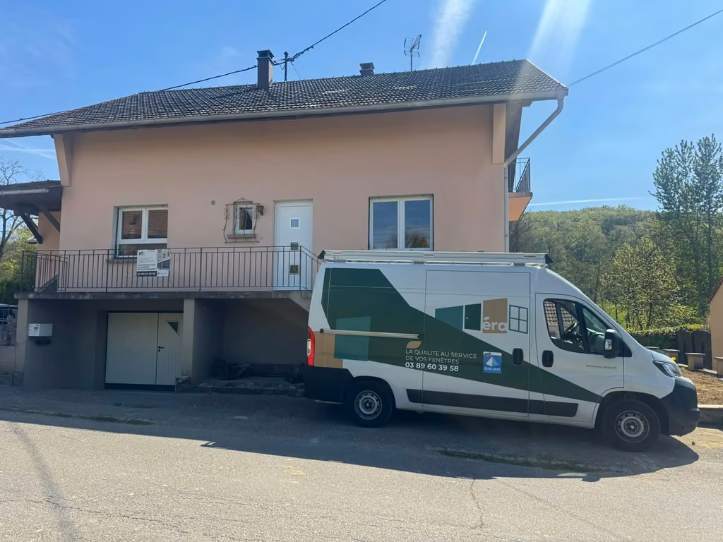 Le fourgon d’ECO RÉNOV ALSACE garé devant une maison au crépi rose, le jour d’un chantier